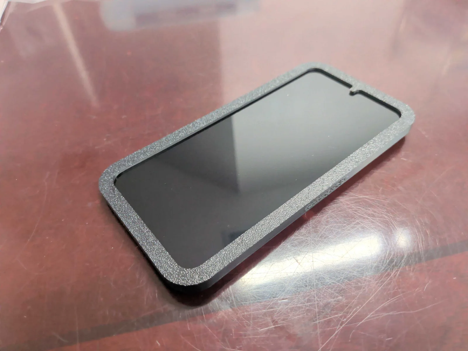Printed installation guide fitted closely around a Galaxy S25 phone screen